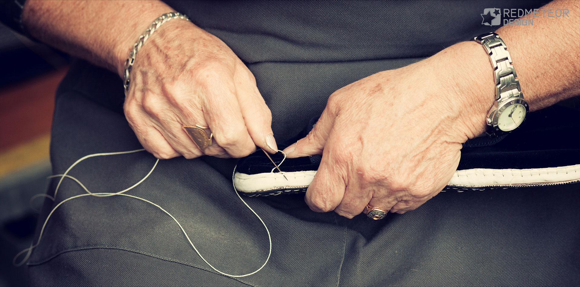 A shoemaker stitching leather by hand